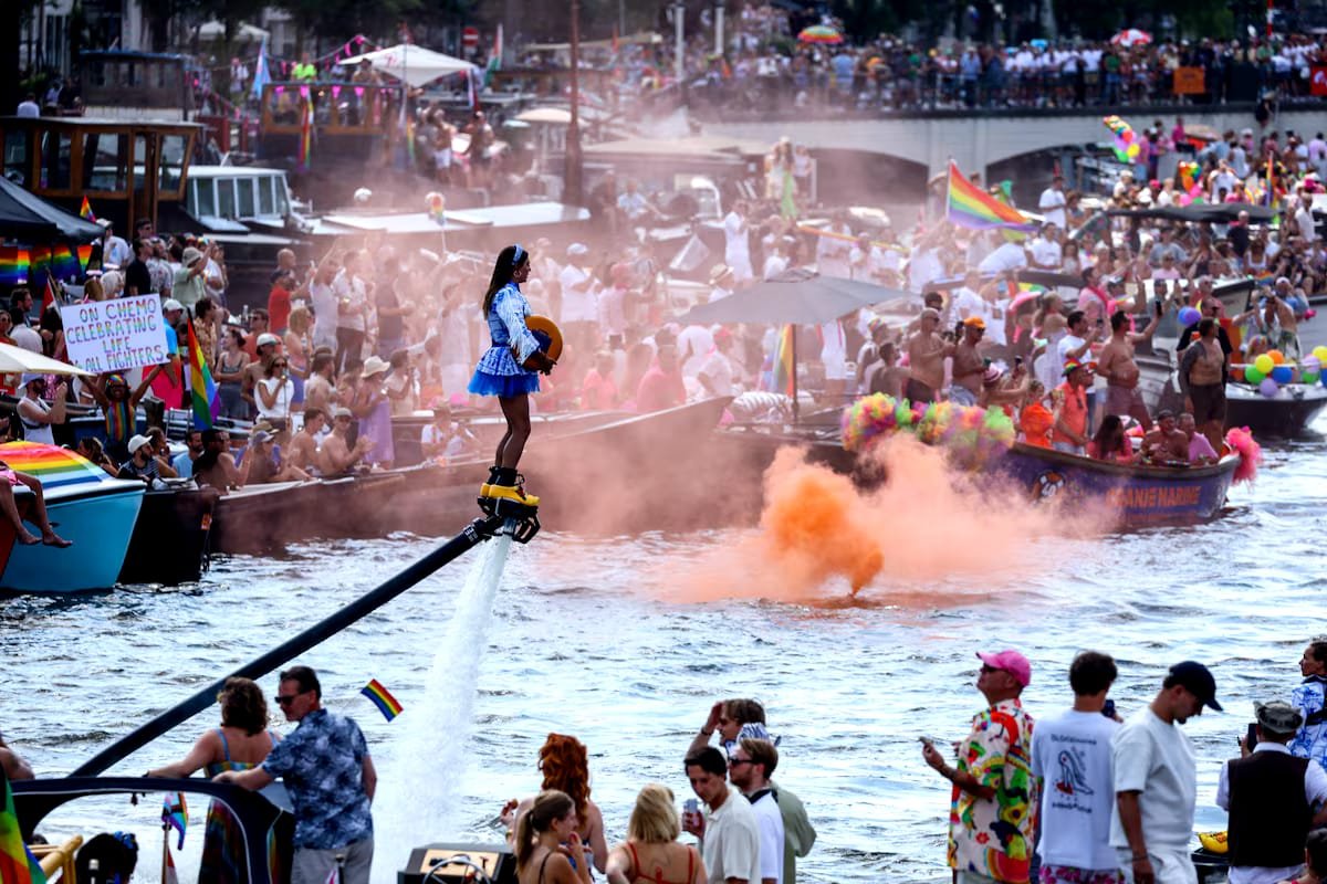 Thousands Gather for Amsterdam WorldPride Canal Parade Under Tight Security After Berlin Attack Participants celebrate during the Amsterdam WorldPride 2026 Canal Parade with rainbow flags and decorated boats.