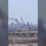 Vehicles pass a signboard near Damietta port in Egypt amid regional conflict