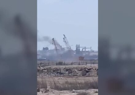 Vehicles pass a signboard near Damietta port in Egypt amid regional conflict