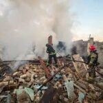 Firefighters work at the site of a house destroyed by a Russian drone strike in Ukraine