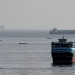 Ships sailing through the Strait of Hormuz as Iran and Oman discuss a temporary plan to reopen the strategic waterway.