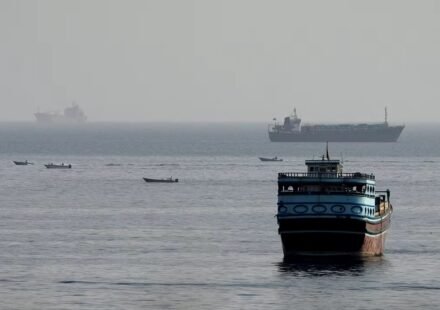 Ships sailing through the Strait of Hormuz as Iran and Oman discuss a temporary plan to reopen the strategic waterway.