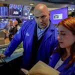Traders monitor stock market movements as S&P 500 reaches record high after strong earnings and AI-driven rally.