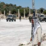 Palestinian man near Israeli troops at the archaeological site of Sebastia in the occupied West Bank