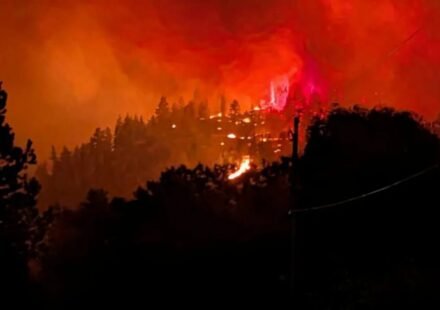 Smoke rises from the Bald Range wildfire over a residential street in Summerland, British Columbia